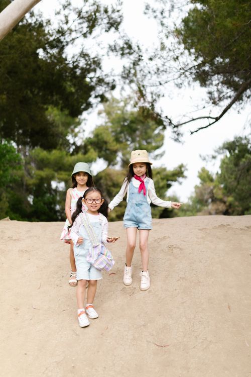 Free Three young girls exploring outdoors on a sunny day, dressed casually for summer adventure. Stock Photo