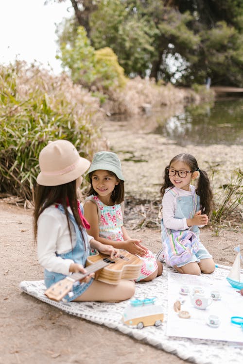 Free 3 Girls Playing on Picnic Blanket Stock Photo