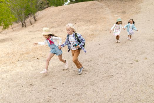 2 Girls in Blue and White Dress Running on Brown Field