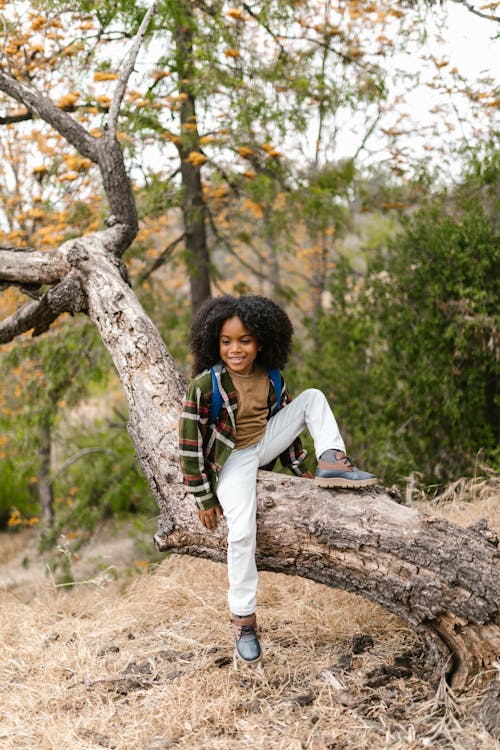 girl sitting against tree