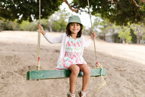 A Girl Sitting on a Wooden Swing