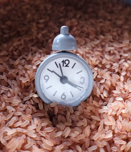 A Close-Up Shot of an Alarm Clock on Grains of Rice
