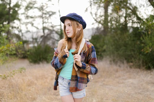 
A Portrait of a Girl Wearing a Blue Hat and a Plaid Shirt
