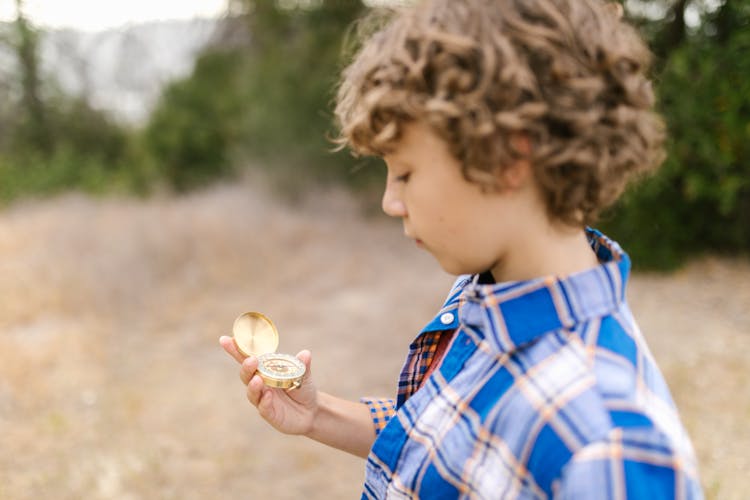 A Boy Looking At A Compass