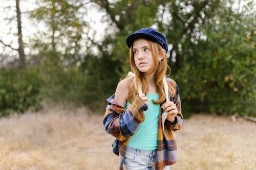 
A Portrait of a Girl Wearing a Blue Hat and a Plaid Shirt
