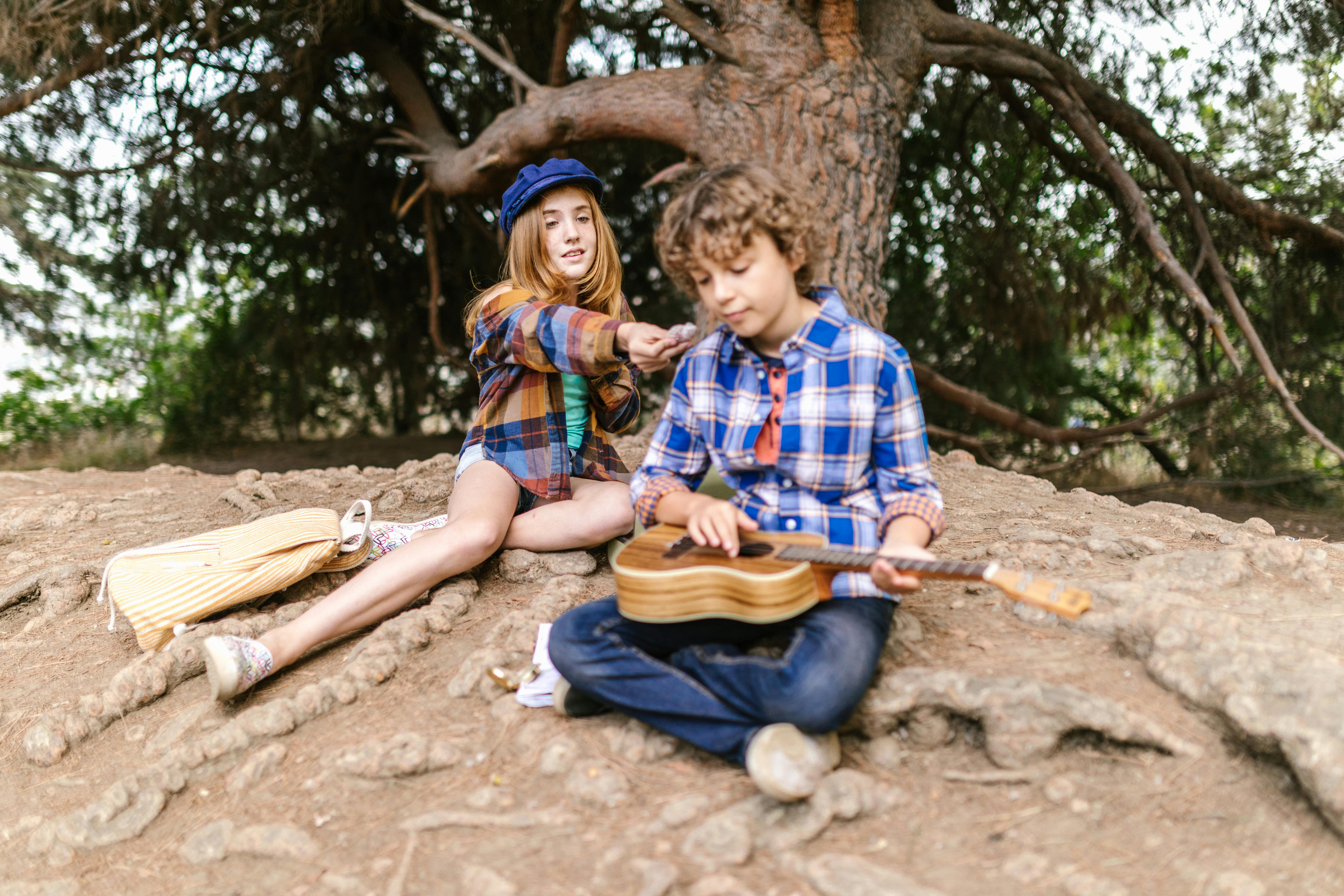 two teens sitting on the ground