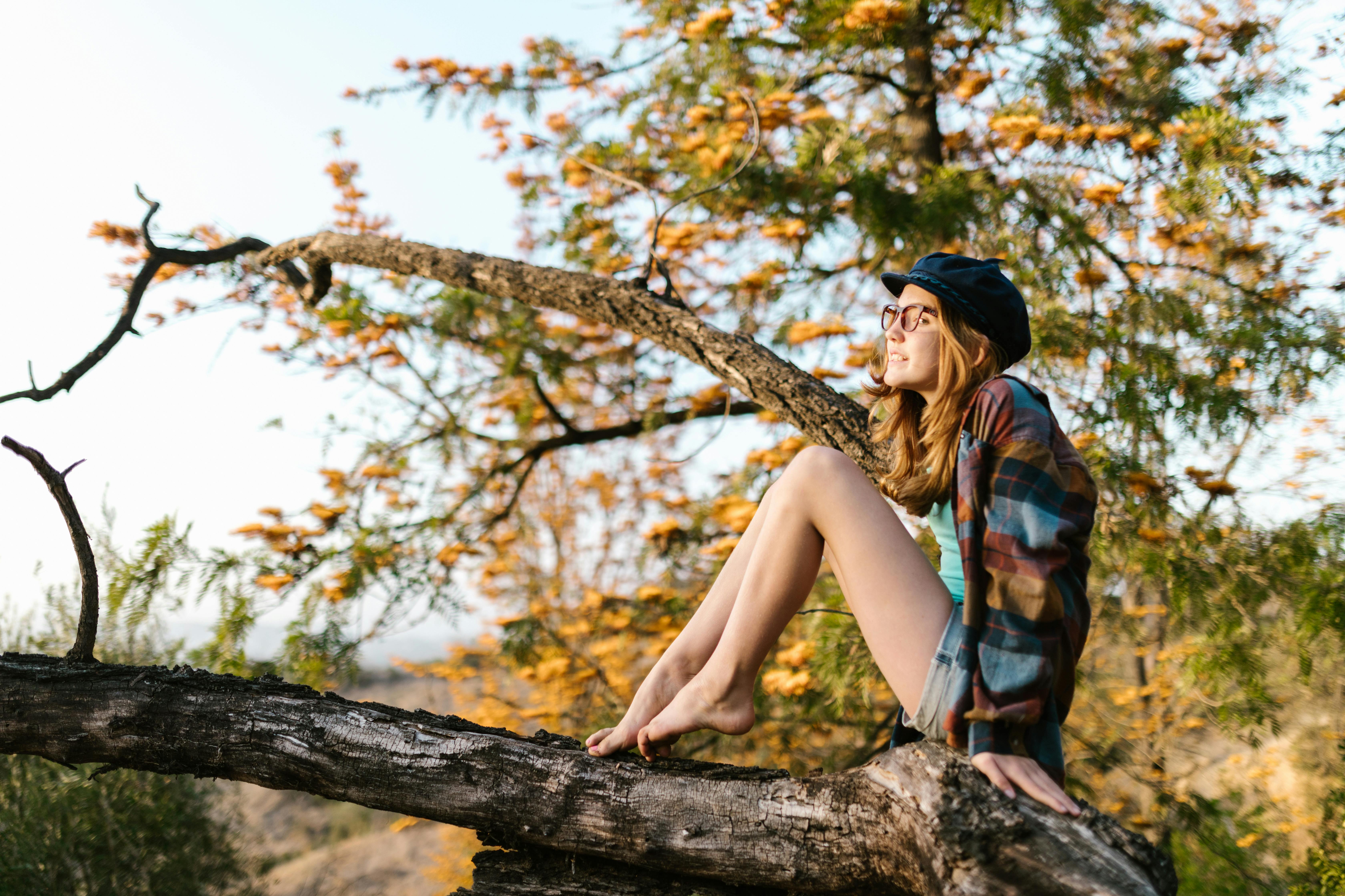 young girl sitting on a tree