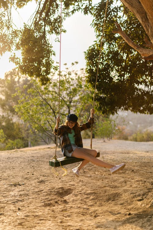 A Girl Sitting on a Swing Hanging on the Tree