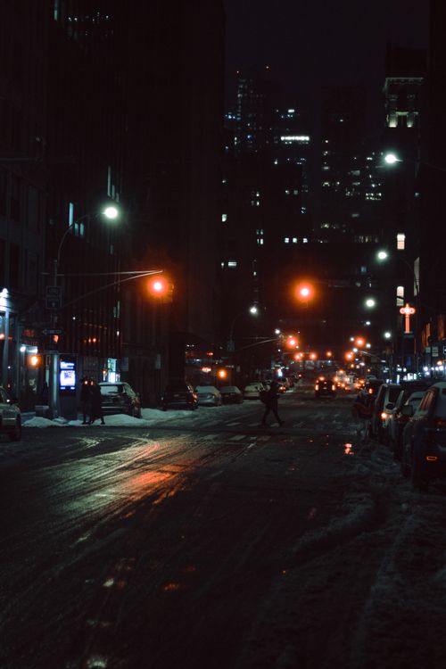 Free Person walking on pedestrian crossing on asphalt road placed in modern city in night time Stock Photo