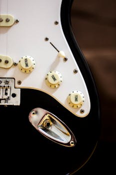 Detailed view of an electric guitar body showing volume and tone control knobs.