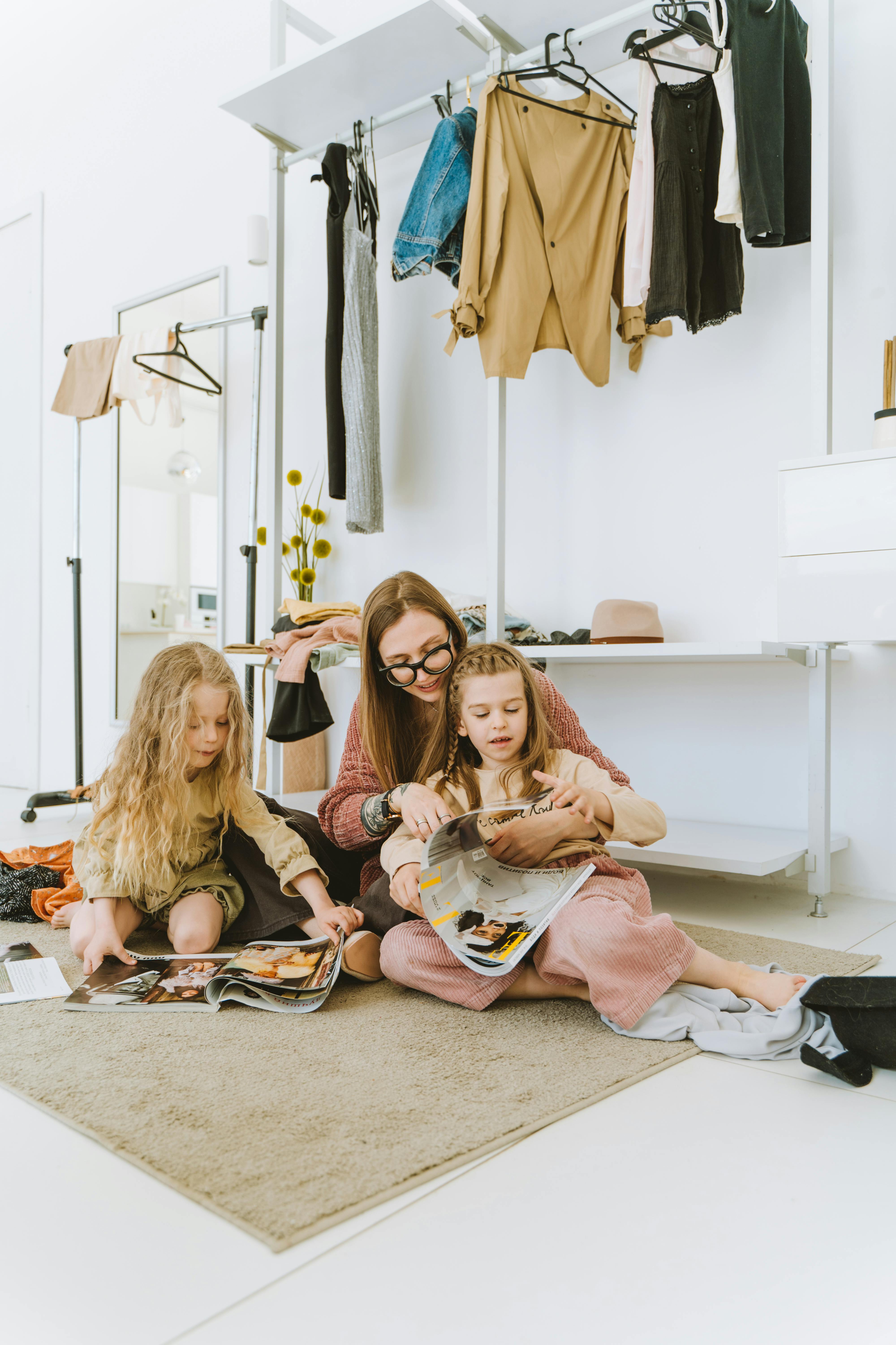 woman with two girls browsing magazines on the floor