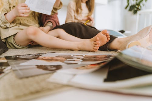 Woman and Two Girls Browsing Magazines
