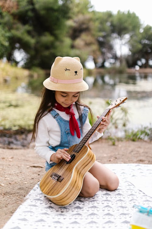 
A Girl Playing the Ukulele during a Picnic