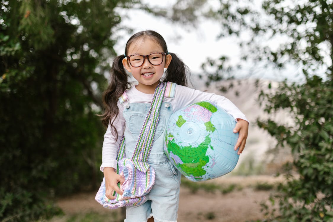 Free Smiling Girl Holding an Inflatable Globe Stock Photo