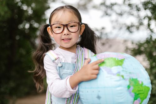 Free Cute child holding a globe in the park, exploring the world. Stock Photo