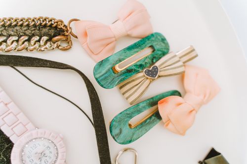 Free Elegant collection of hair clips, bows, and wristwatch on a white background. Perfect for fashion and accessory themes. Stock Photo