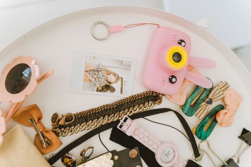 Free Flat lay of various accessories and a pink camera capturing vibrant style. Stock Photo