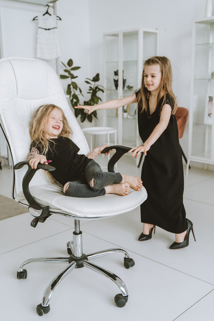 Two Girls Playing With Office Chair