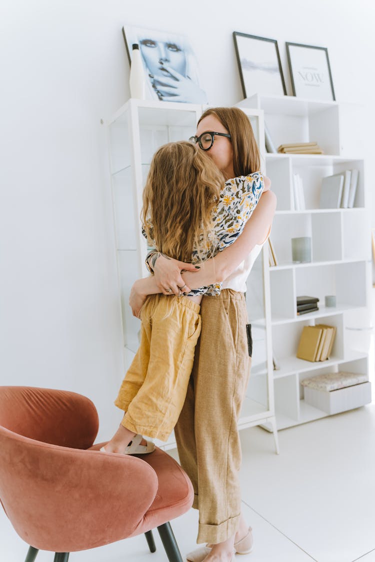 A Woman Hugging A Girl