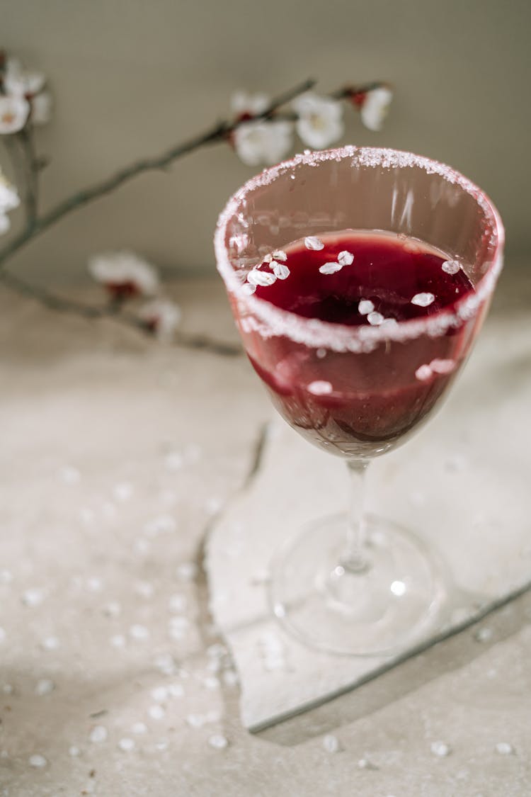 A Red Liquid On A Cocktail Glass With Salt