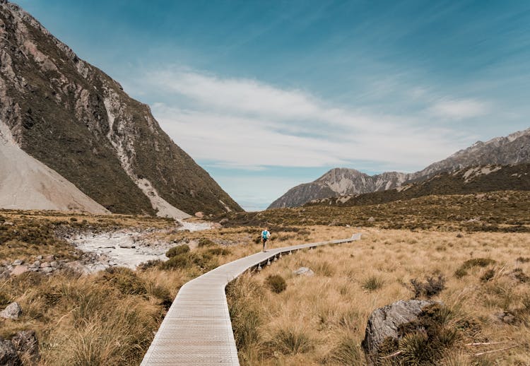 Photo Of A Man Walking On Boardwalk