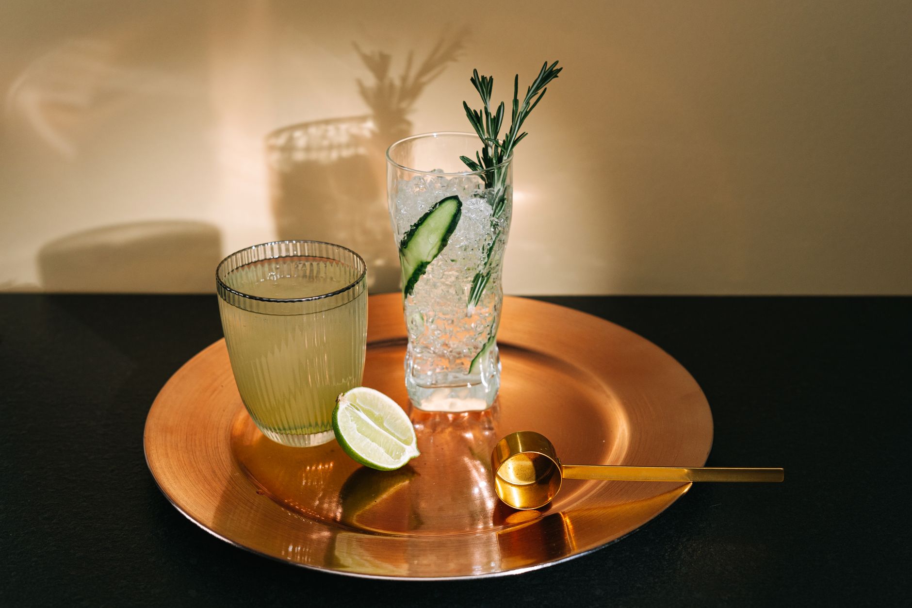 A bartender holding a stemmed cocktail glass against a blurred bar background
