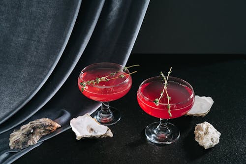 Close-Up Shot of Two Glasses of Cocktail Drinks on Black Surface