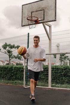 A young man enjoying a game of basketball on an outdoor court.