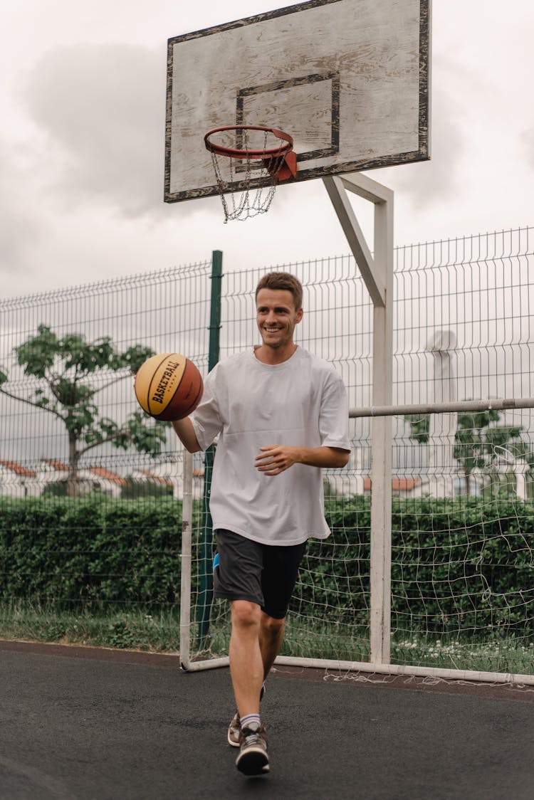 Man In White Shirt And Black Shorts Playing Basketball 