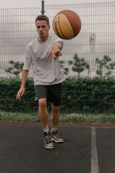 Young man playing basketball on an outdoor court, showcasing active lifestyle.