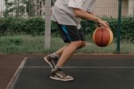 Man in White Shirt and Blue Shorts Playing Basketball