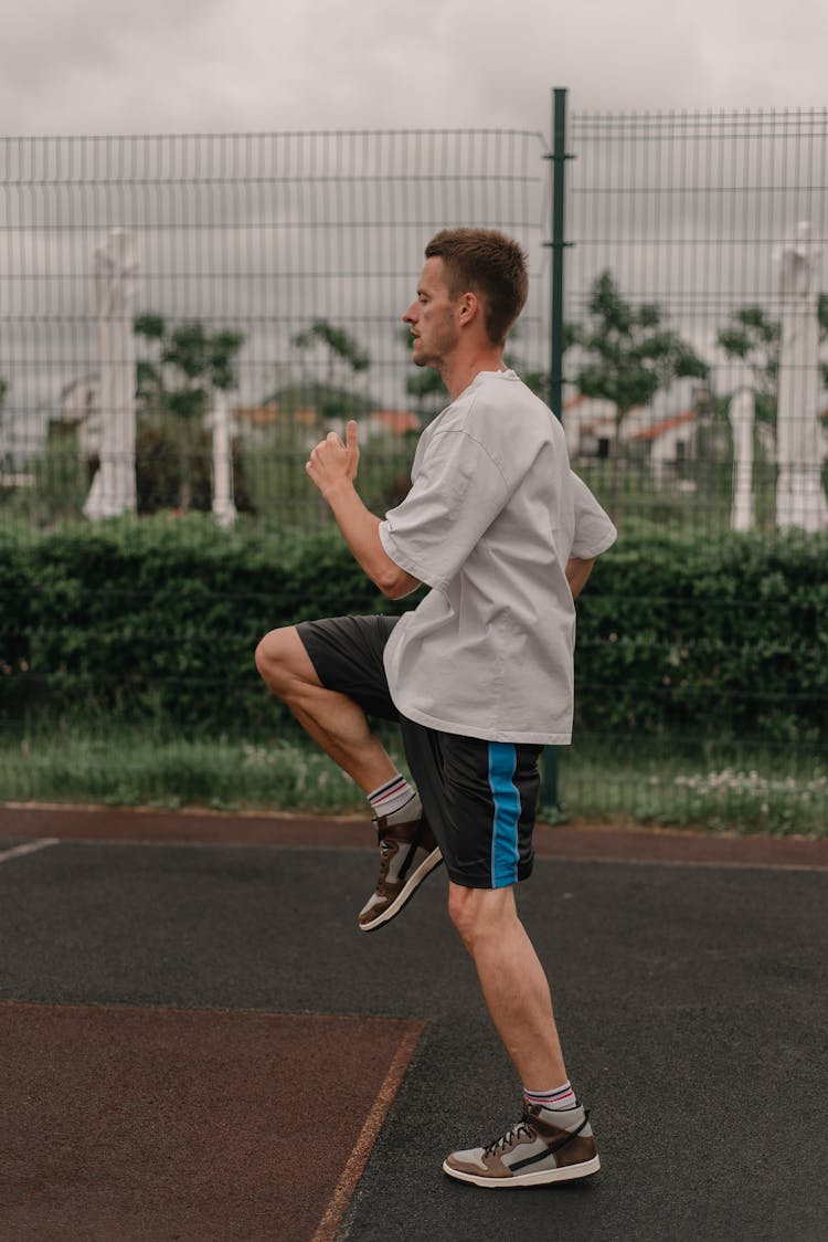 Man In White Shirt Wearing Rubber Shoes While Running 