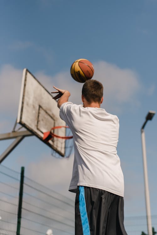 A Man Shooting a Basketball Via Jump Shot