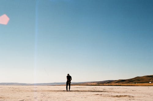 Free Silhouette of a Man on a Sunny Beach  Stock Photo