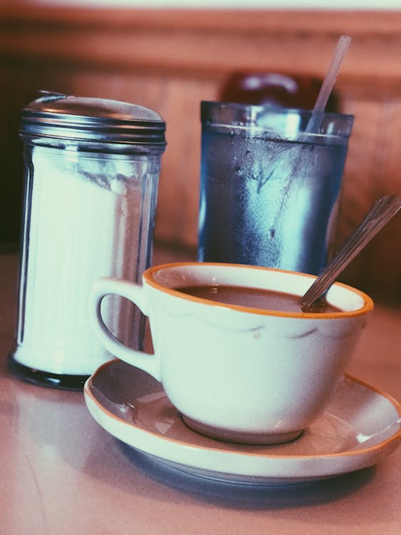 Free White Ceramic Mug Fill With Coffee Beside Condiment Shaker Stock Photo