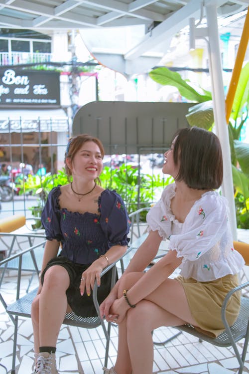 Teenage Girls Sitting on Chairs While Having a Conversation