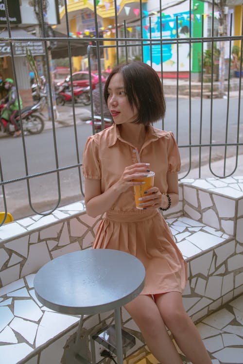 A Woman Sitting holding her Drink