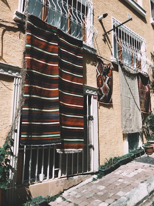 Carpets hanging on windows of residential building
