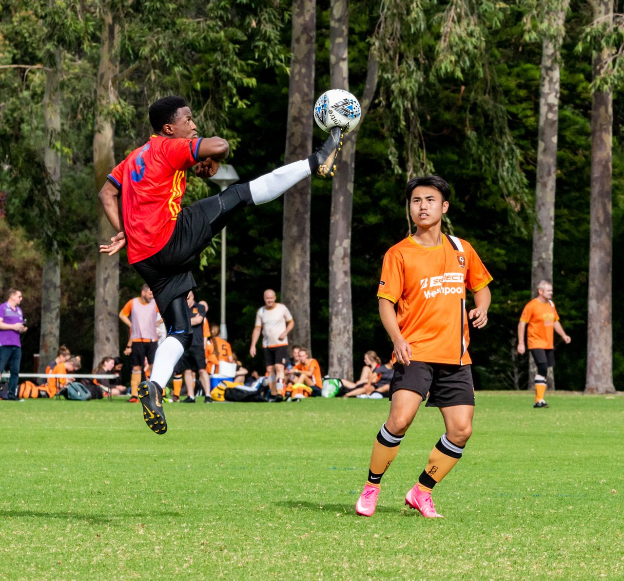 exciting soccer game moment with athlete kicking the ball mid air on a