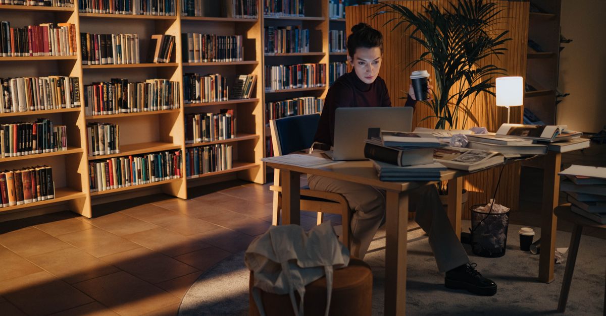 Student studying late at night with AI chatbot open on laptop, looking relieved