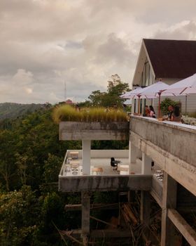 Modern resort perched on a cliff, offering stunning views of lush mountains and leisure activities.