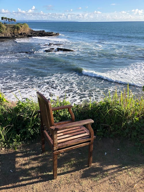 Free A Wooden Arm Chair Near the Sea Stock Photo
