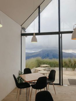 Cozy indoor seating area overlooking a scenic mountain view through glass panels.