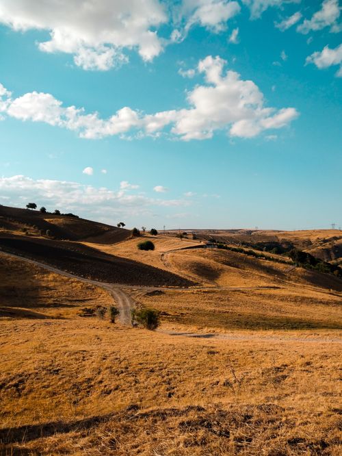 Free A scenic view of rolling hills and a clear blue sky, capturing the essence of a sunny countryside. Stock Photo