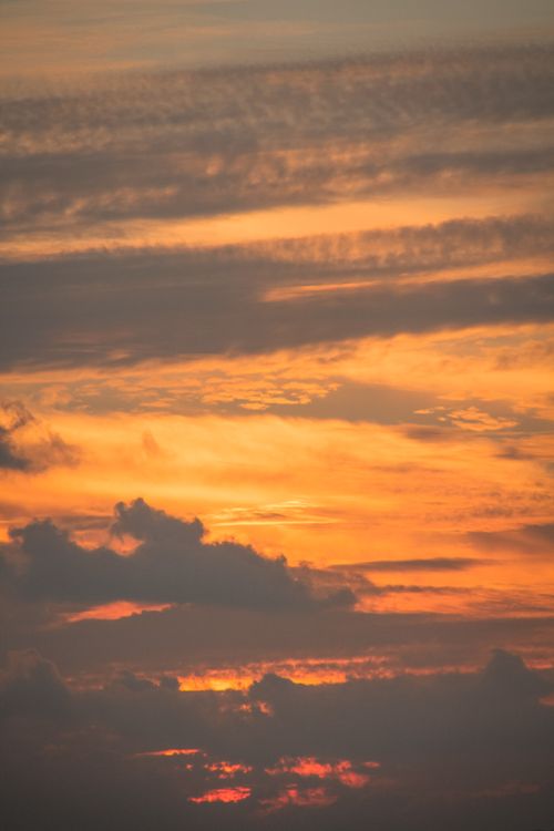 Free A breathtaking shot of a golden sunset with dramatic cloud formations filling the sky. Stock Photo