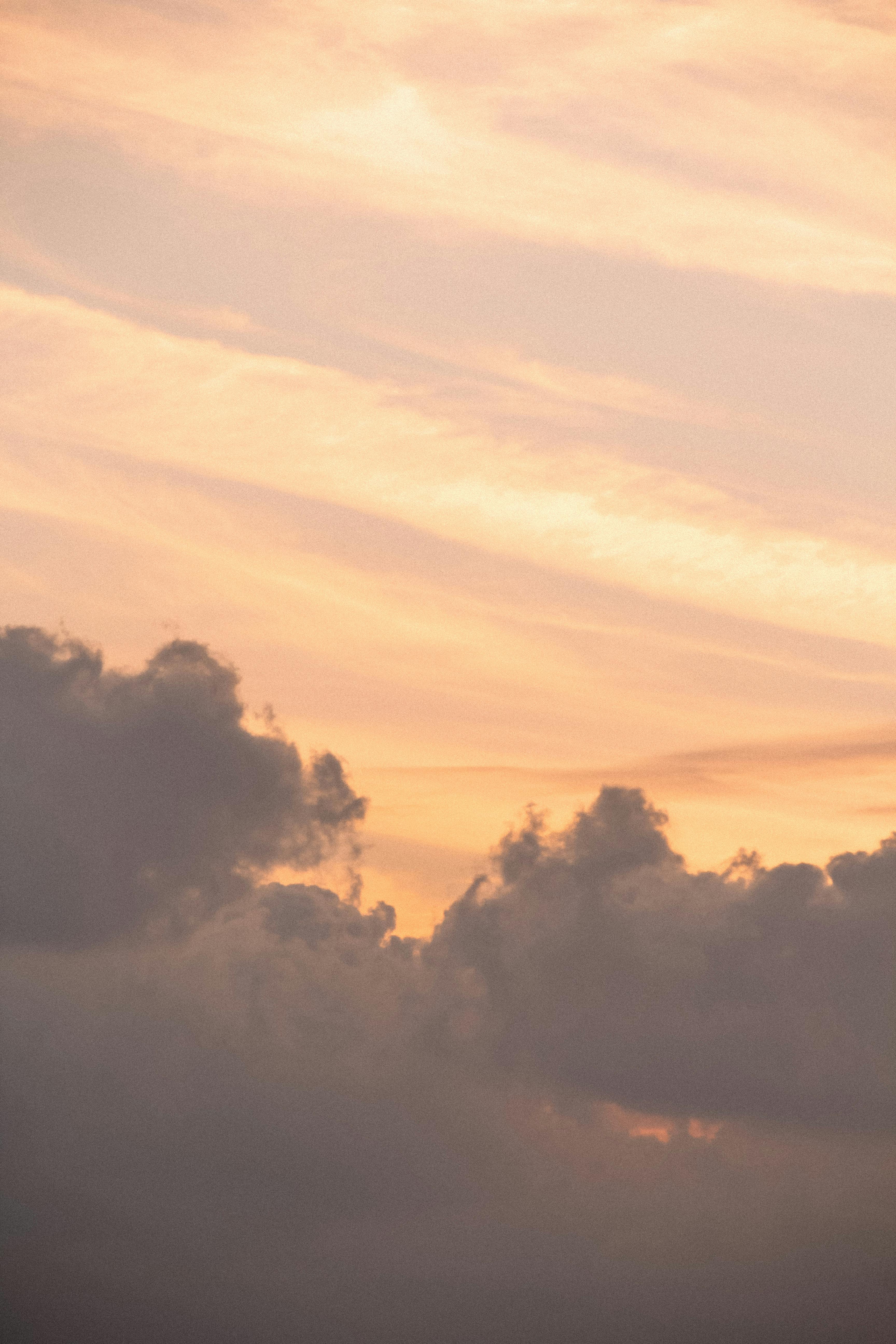 Tranquil sunset sky with soft, warm clouds creating a peaceful atmosphere. Ideal for backgrounds.