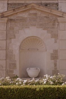Stone facade with decorative vase and flowers in Beverly Hills, showcasing elegant architectural design.
