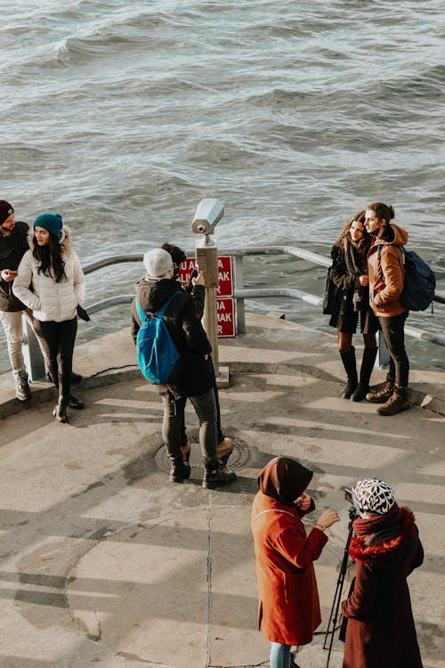 People Standing on Pavement on Sea Shore