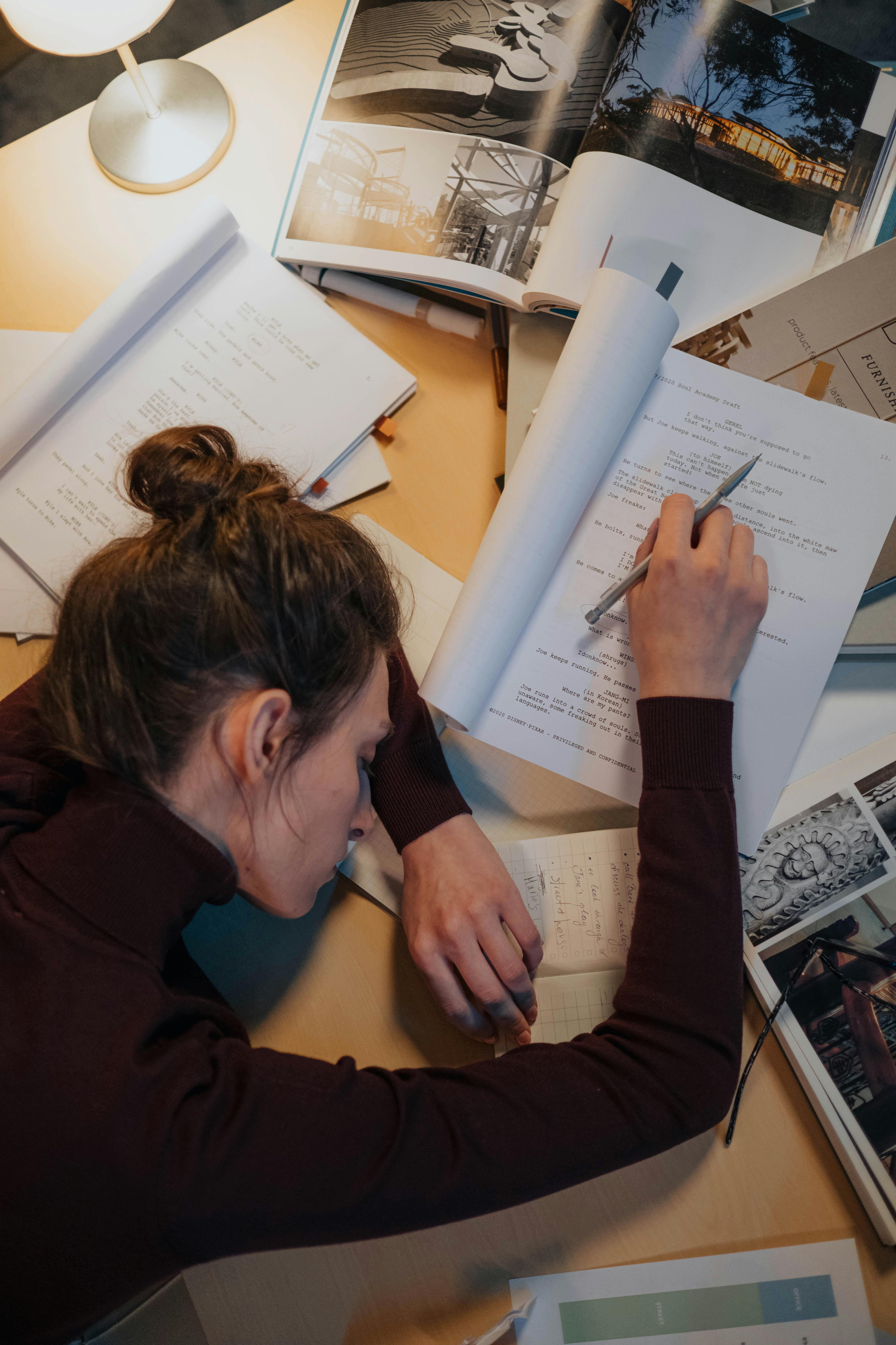 a girl in maroon dress on a table full of work exhuasted