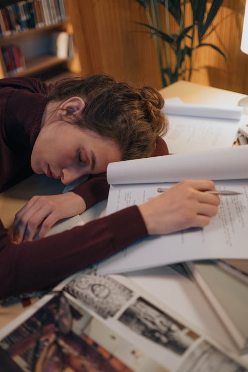 Free Young Woman Sleeping with Her Head on the Books  Stock Photo